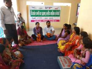 Sabene sits at a local community members meeting