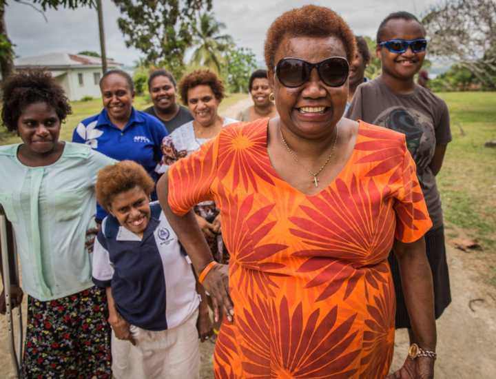 Nelly Caleb standing in front of a group of people with disabilities in Vanuatu.