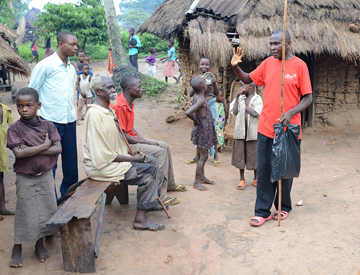 A group of people listening to a CBM staff member.