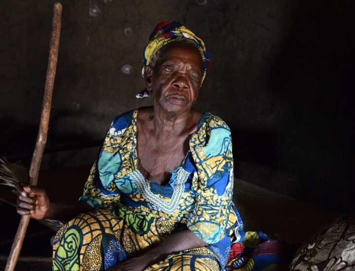 Mama Muni sitting at her home