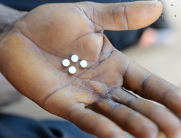 Four antibiotics to treat River Blindness in the palm of a man's hand.