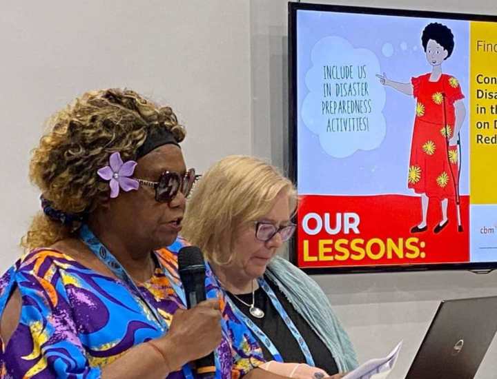 Nelly Caleb from the Vanuatu Disability Promotion and Advocacy Association, speaks on a microphone to share findings from the Consultation of People with Disabilities