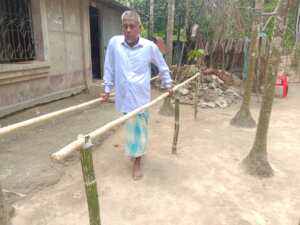 Image caption: Siddique uses parallel bars built outside his home to practice walking. 