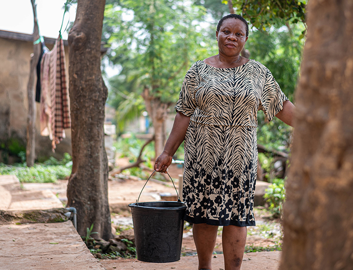 Chizoram filling up a bucket of water.