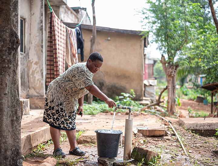 Chizoram filling up a bucket of water.