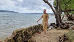 Image caption: Anna points to where the rising sea level has started to wash away barriers that keep communities safe.  