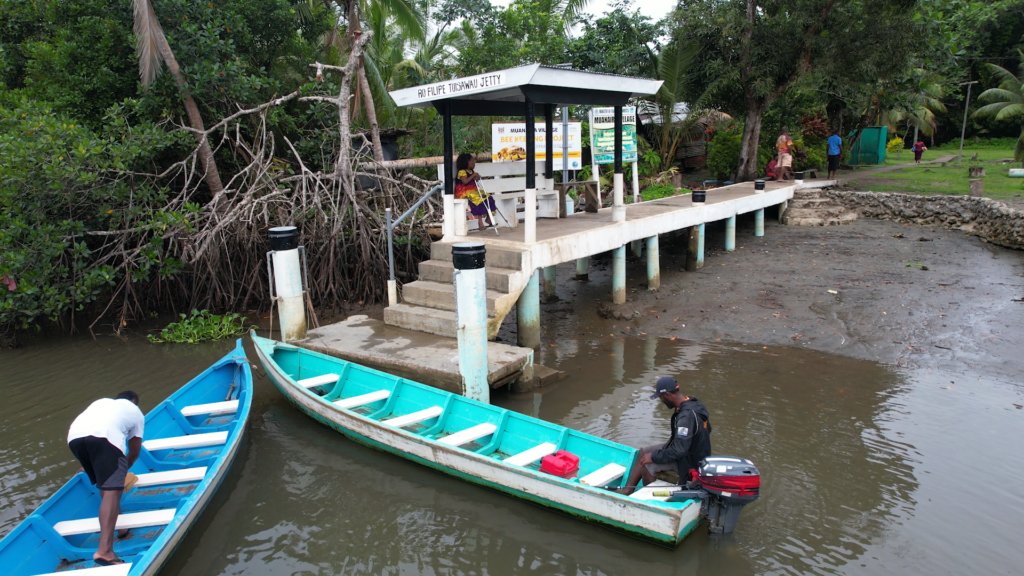 Lusiana waiting at the village wharf for a boat ride into the township.