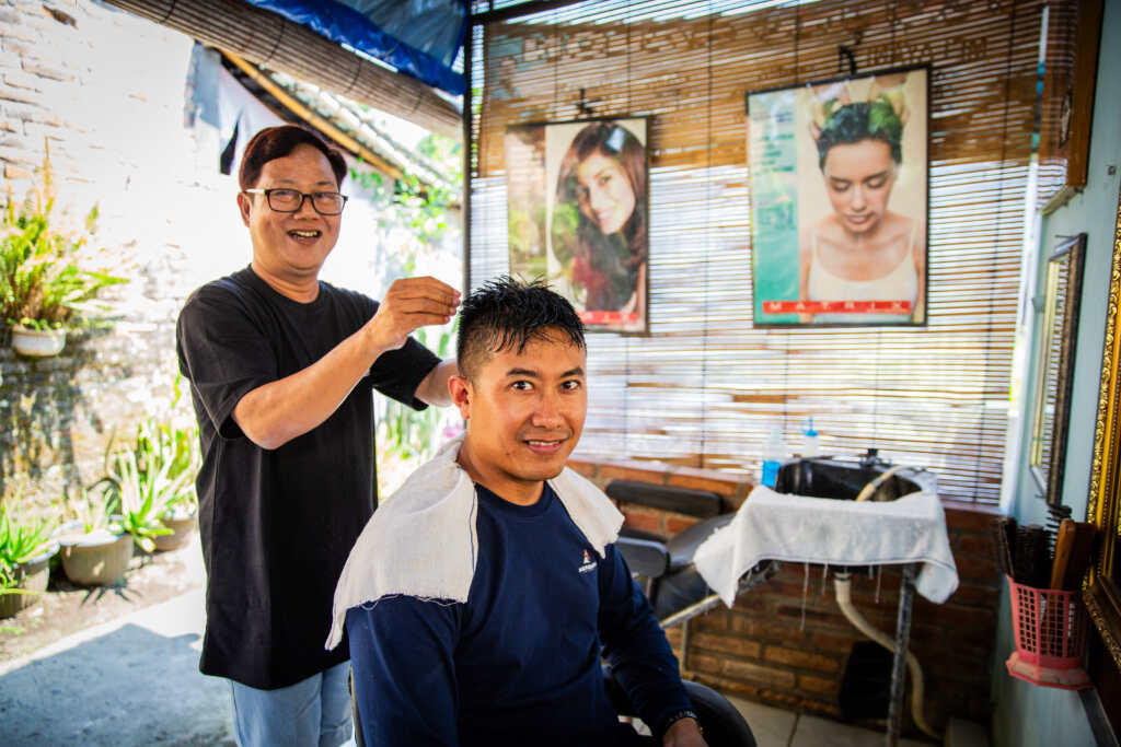 Sugeng and a client in his salon.