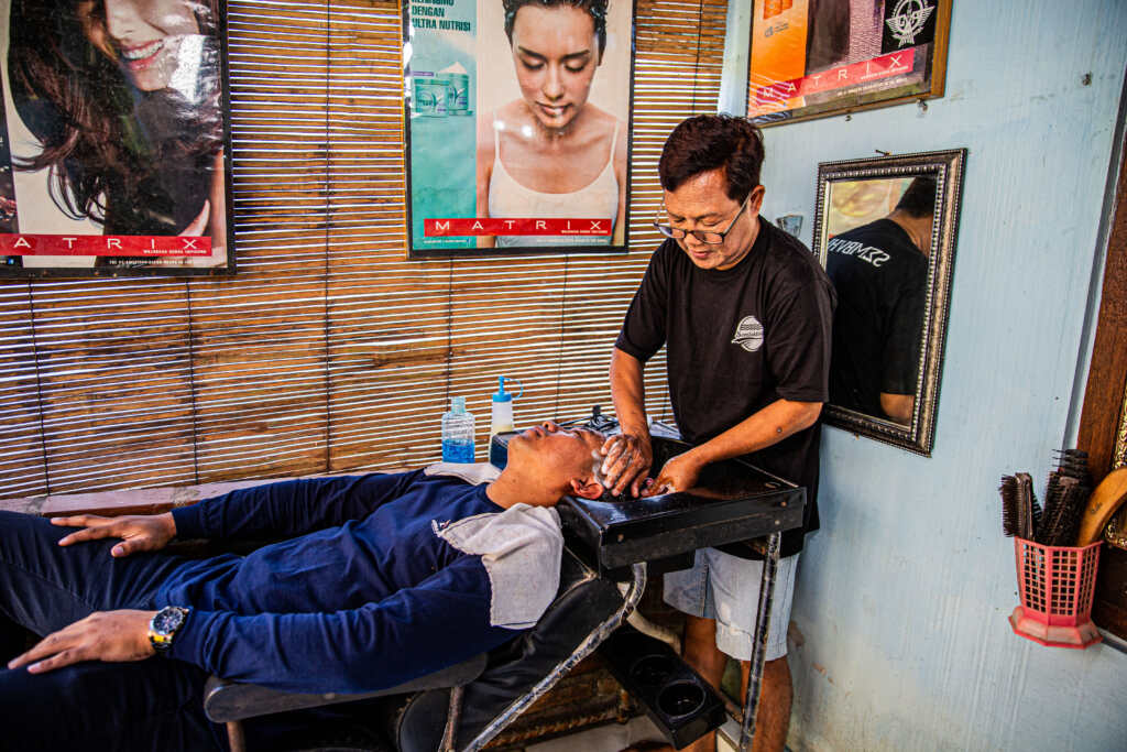 Sugeng washing a client’s hair.