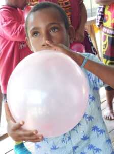 Image caption: Speech therapy made fun. Eddy blowing up a balloon to strengthen his tongue and improve his speech.