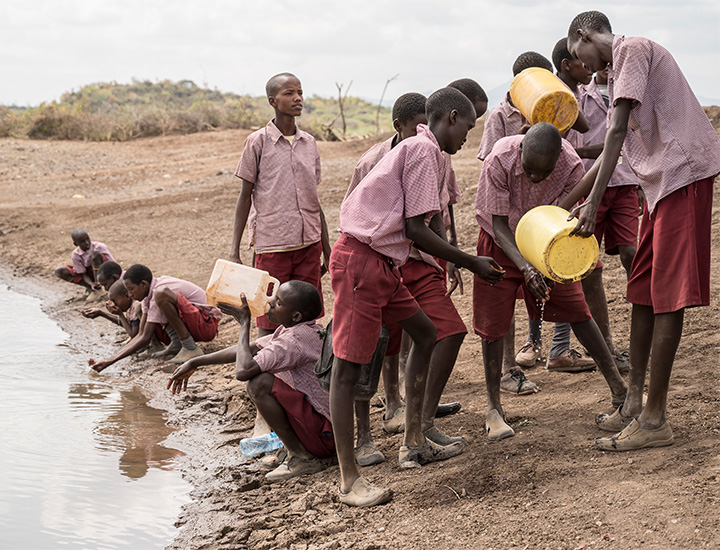 An image of children carrying water