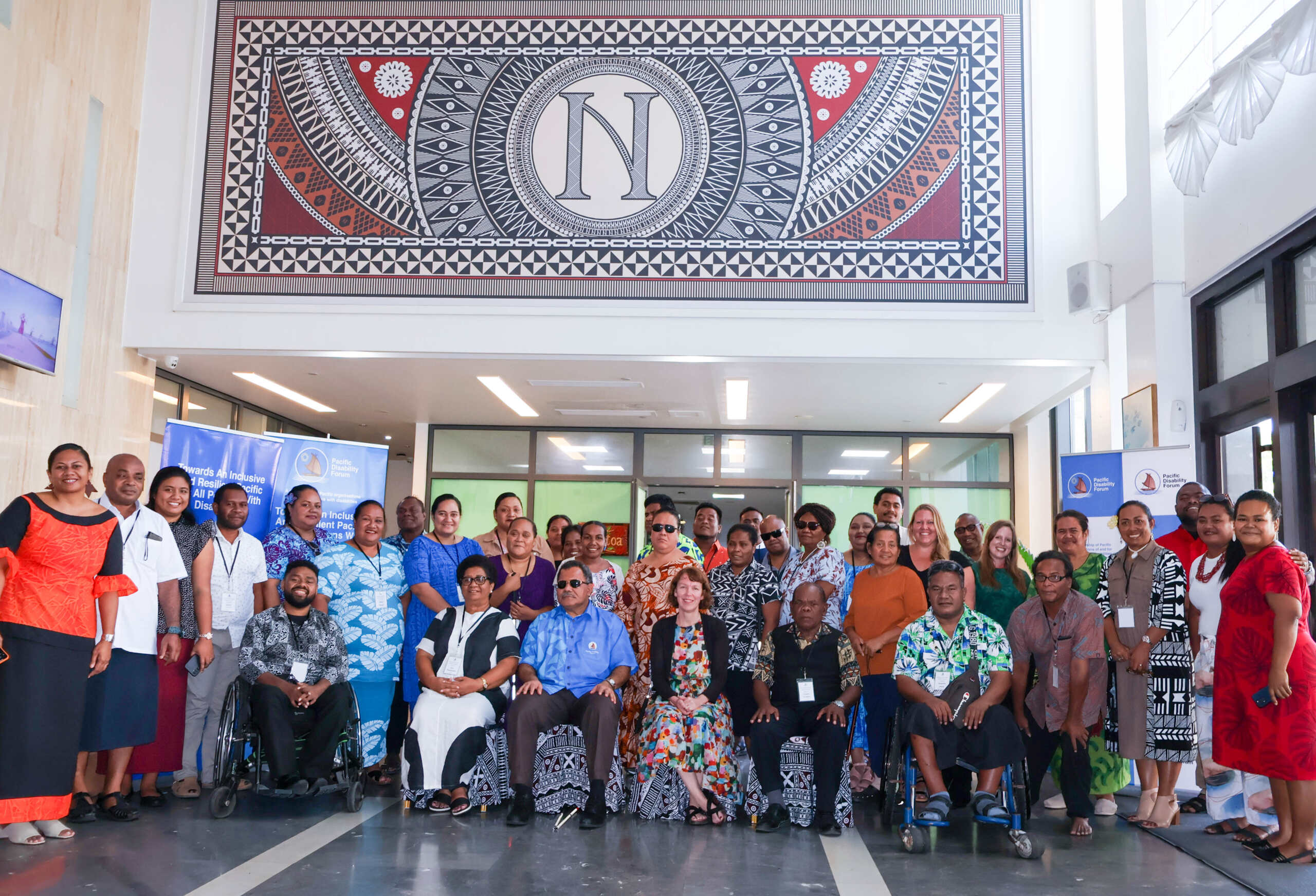A large group of people both seated and standing in two rows representing Growing Stronger Together initiative.