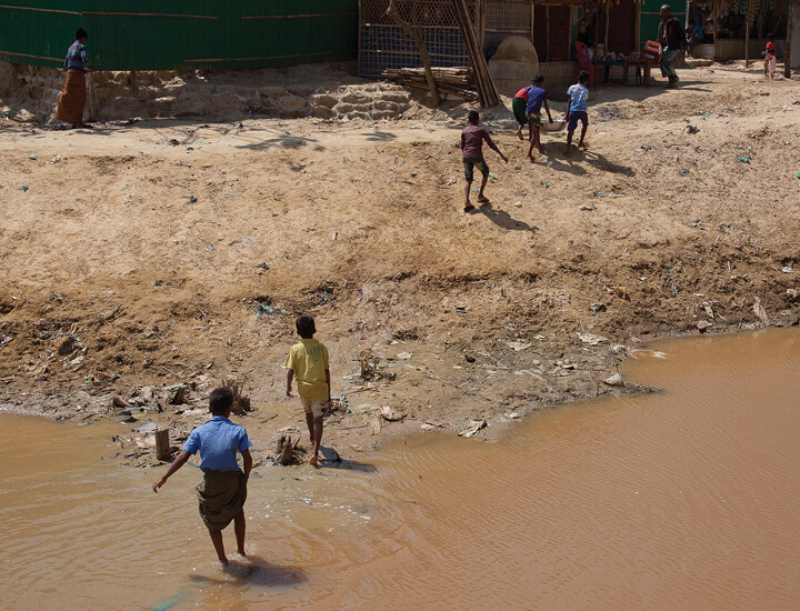 An image children playing in a dirty river