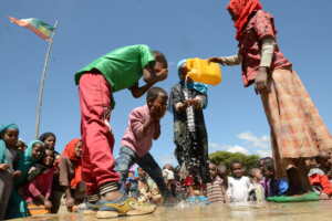 A group of children washing their faces with water