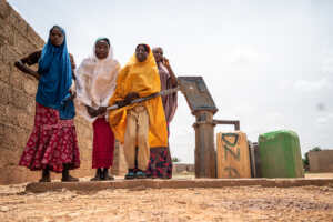 A group of people standing next to a water well