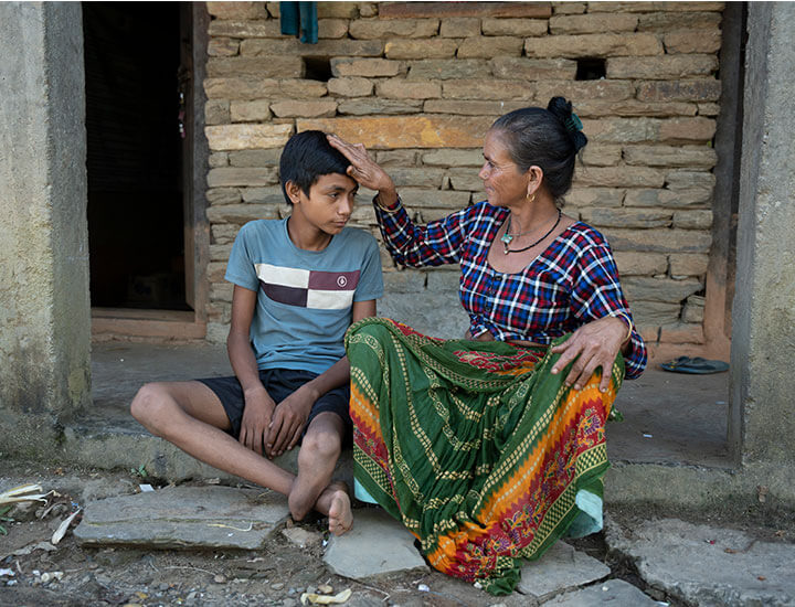 Boy getting patted on the head by older woman