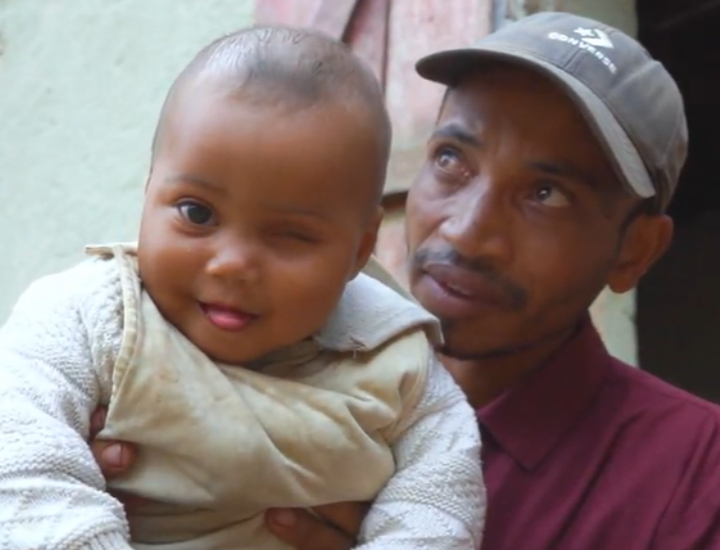 Sombiniaina being held by her father