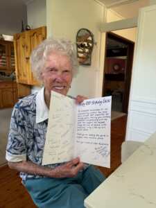 CBM supporter Edith holding a card signed by CBM Australia staff