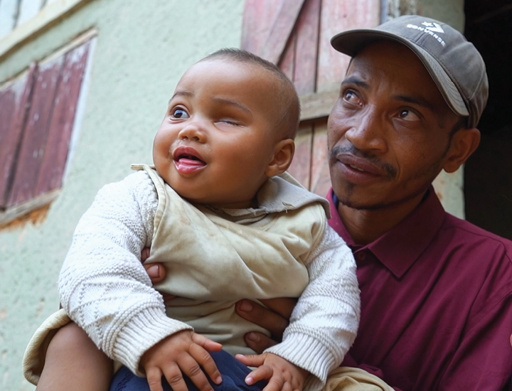 A child and her dad holding her